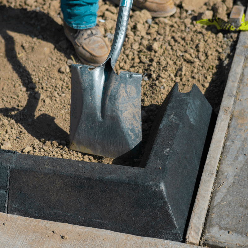 Person shovels soil along Hercules Eco Block