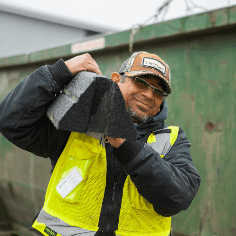 Worker in yellow vest hoists Hercules Eco Block on his shoulder.